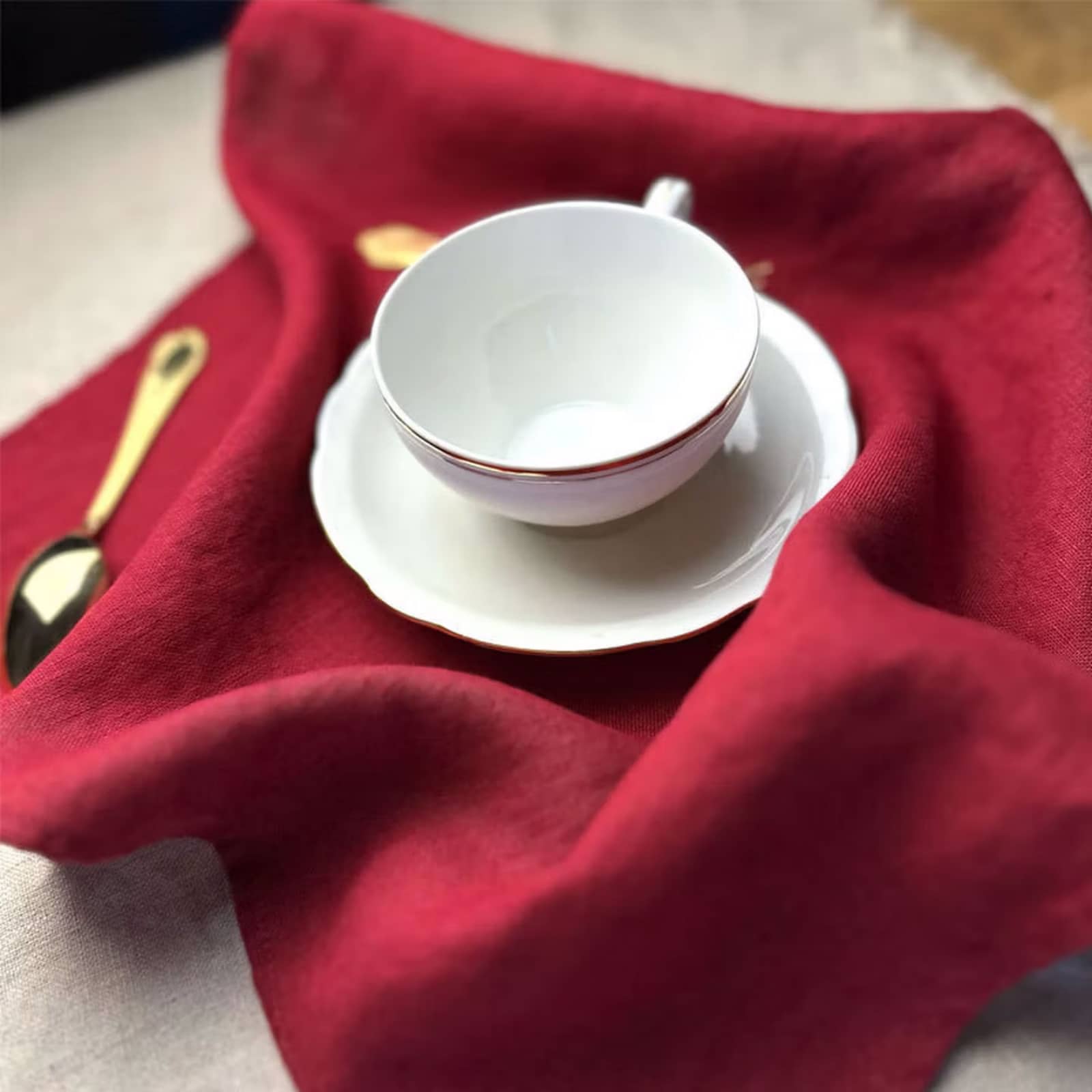 Burgundy red linen placemat with coffee cup and gold spoon
