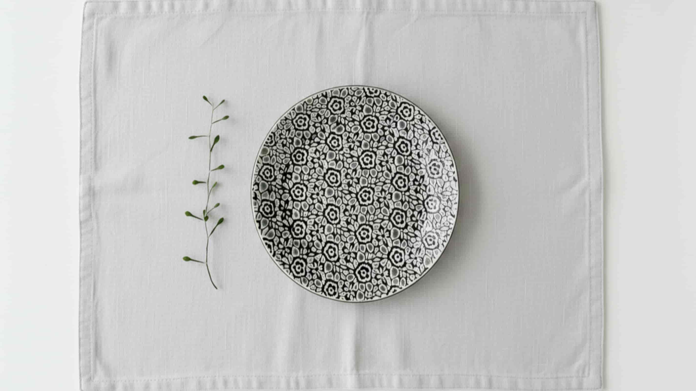 Light grey linen placemat with ceramic plate overhead minimal