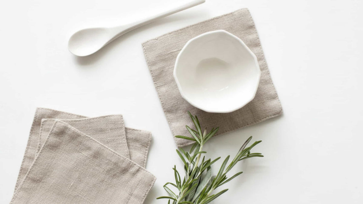 European linen coaster set displayed in an elegant overlapping arrangement on a white background.