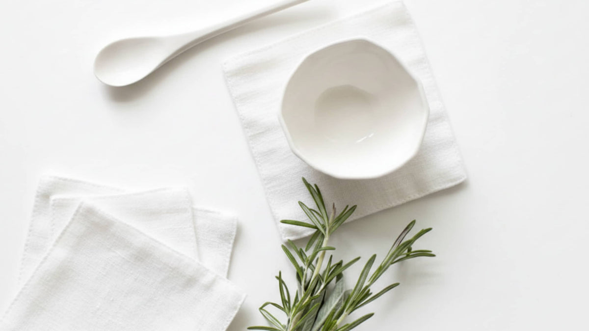 European linen coasters styled on a fine dining restaurant table with ceramic tableware and crystal glassware.