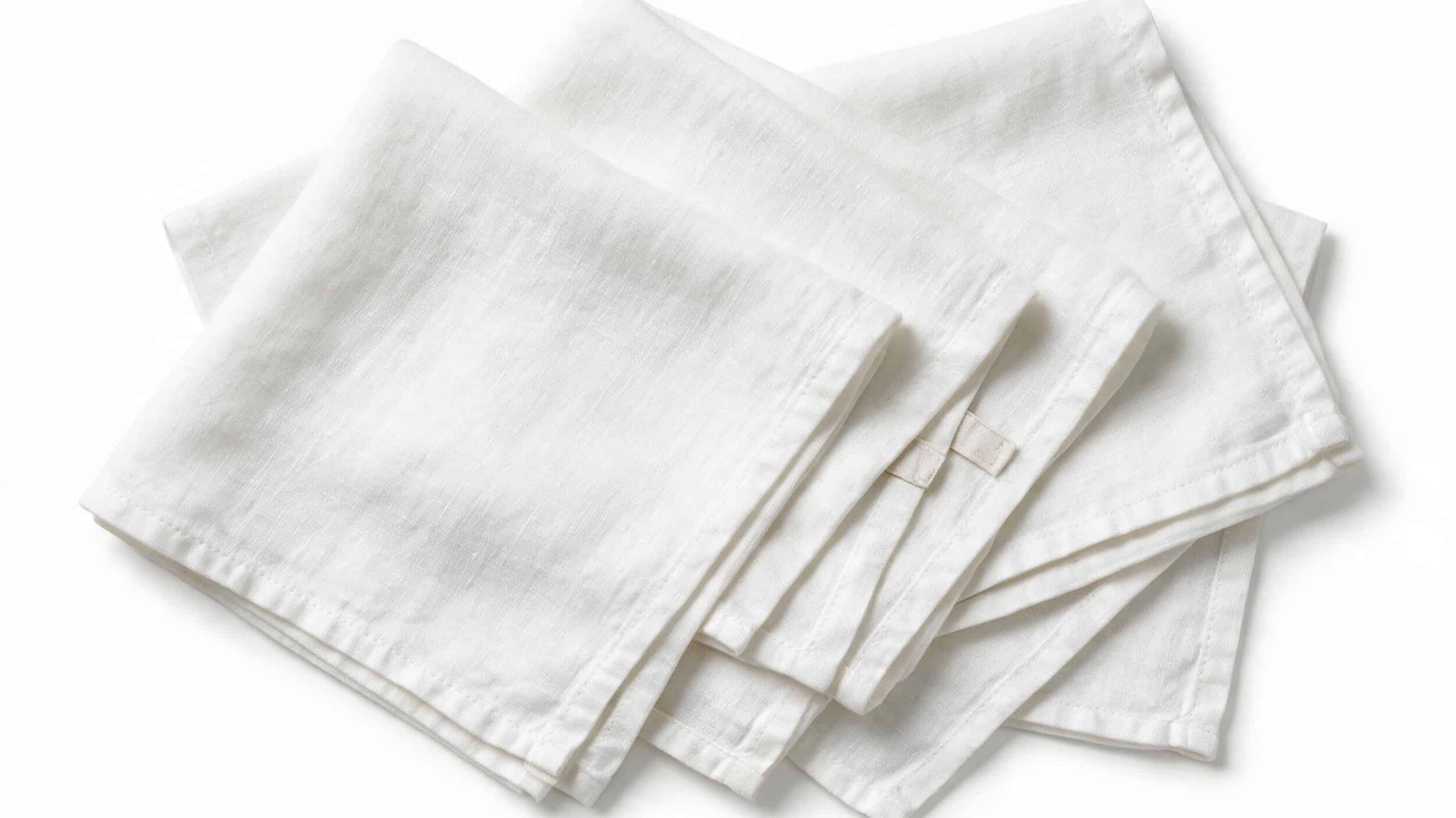 Collection of white European linen tea towels arranged together showing authentic linen texture and natural folds.