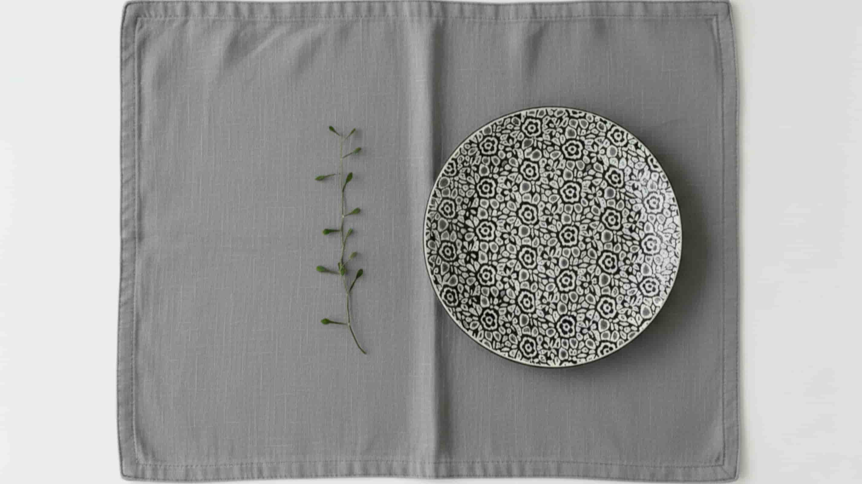 Middle grey linen placemat with ceramic plate overhead minimal