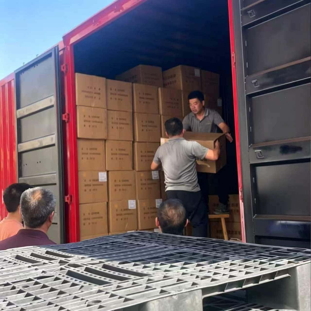 Linen bulk order being loaded into red container on sunny day