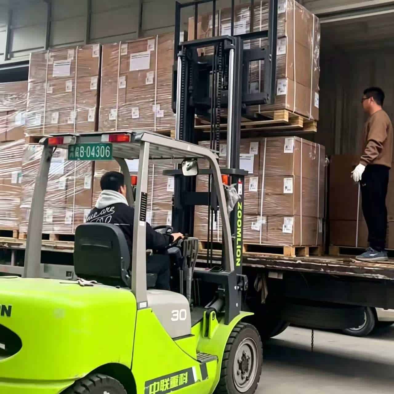 Forklift loading linen pallet onto truck in warehouse