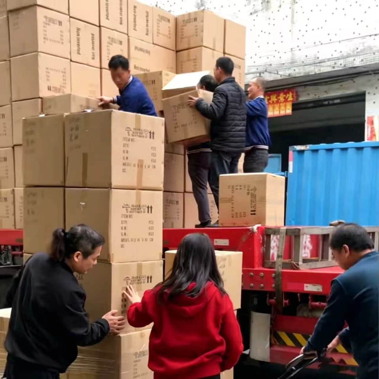 Team manually loading linen bulk order into blue container