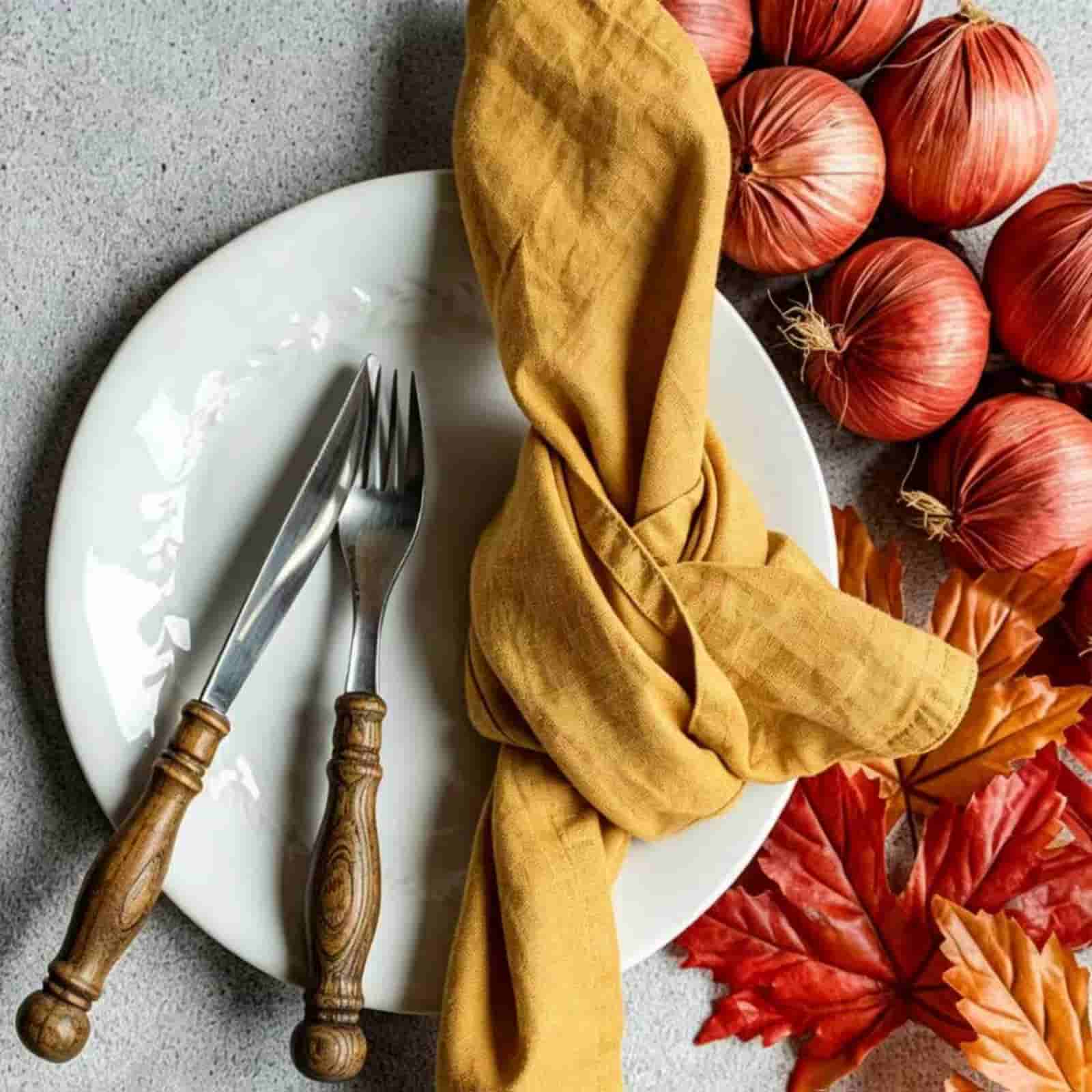 Mustard yellow wholesale linen napkin with autumn harvest onions and fallen leaves styling